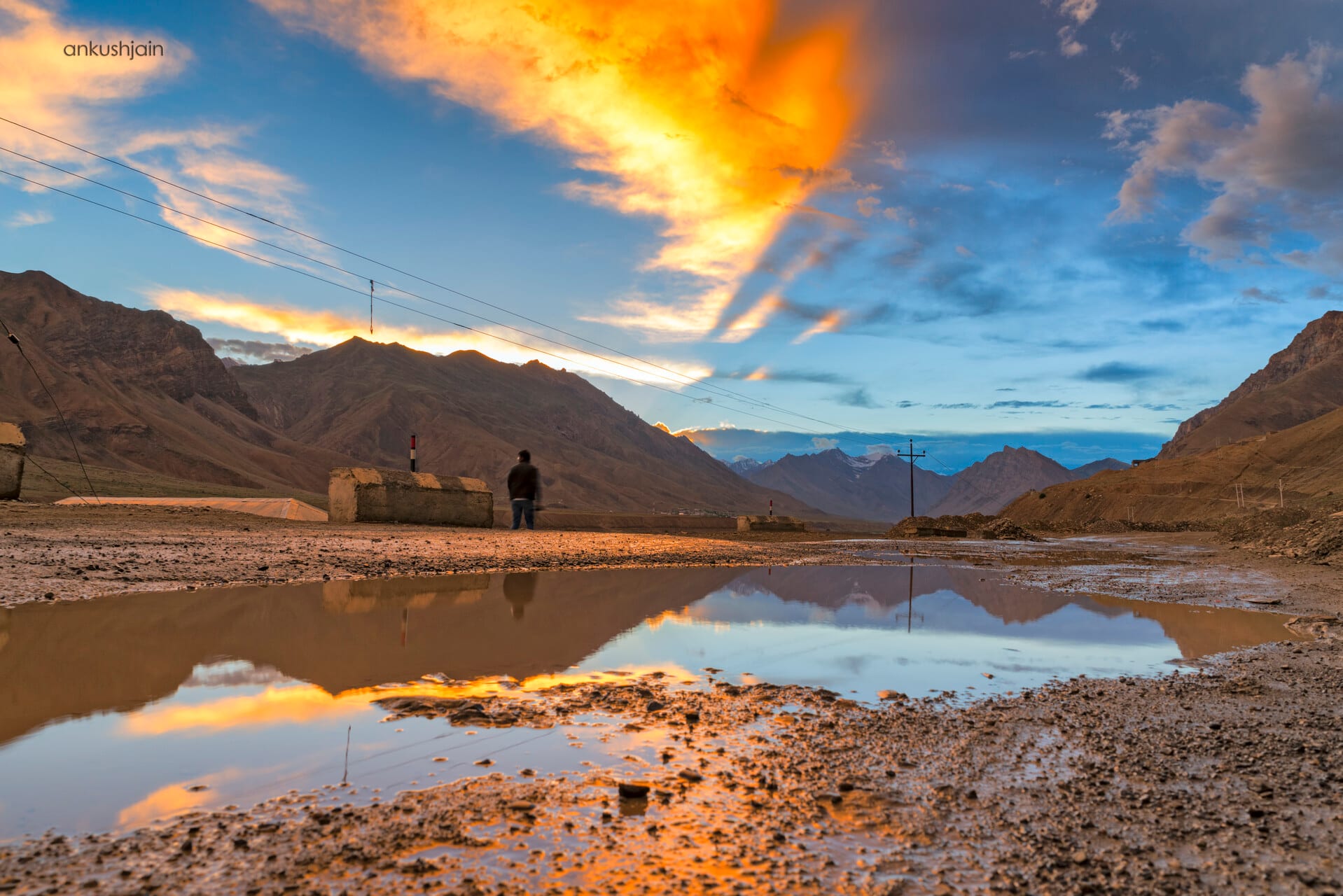 A mountain sunset, the sky banded orange and violet over dark ridgelines
